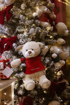 Cozy holiday display featuring teddy bears on a decorated Christmas tree.