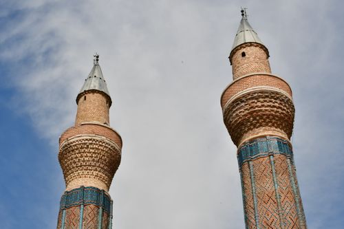 Free Detailed view of the twin minarets of Gök Medrese against a blue sky in Sivas, Türkiye. Stock Photo