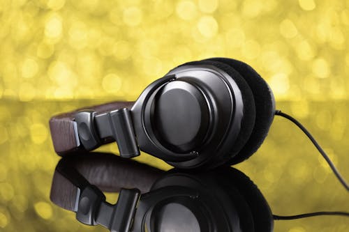 Black Corded Headphones on Reflective Surface