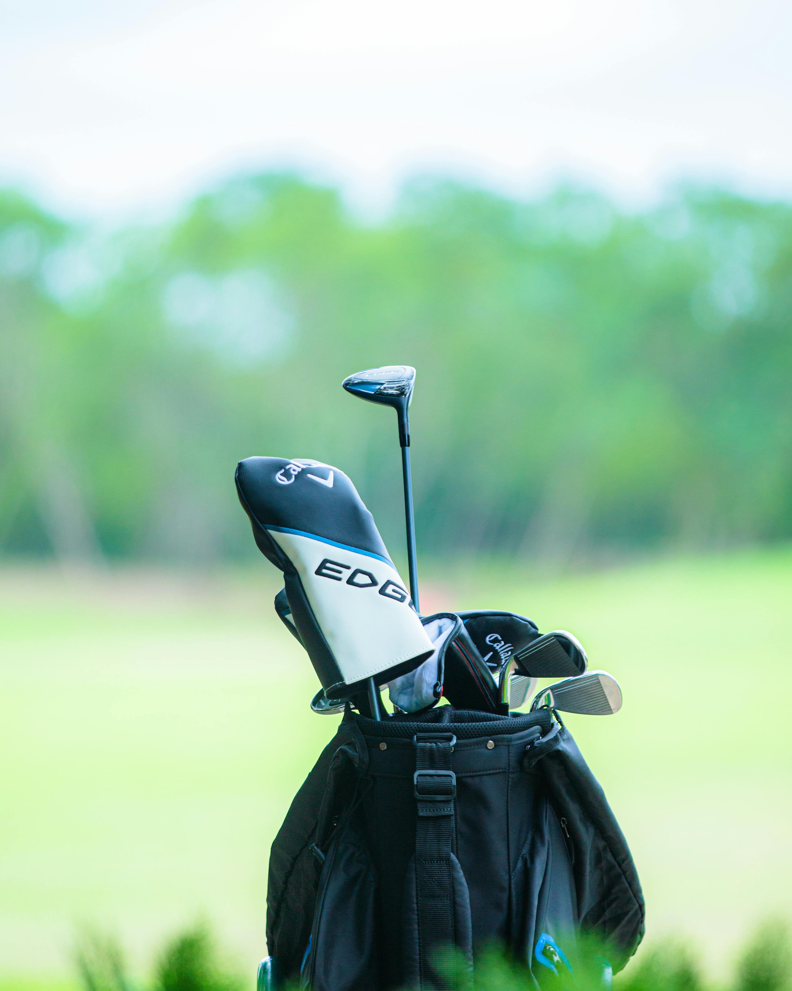 Golf clubs in a bag on a lush green course, ideal for sports enthusiasts.