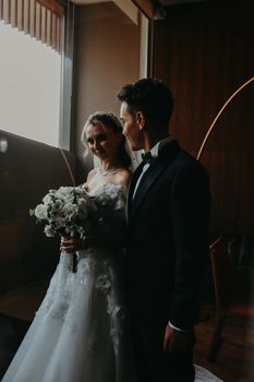 A romantic moment between a bride and groom indoors, beautifully captured.