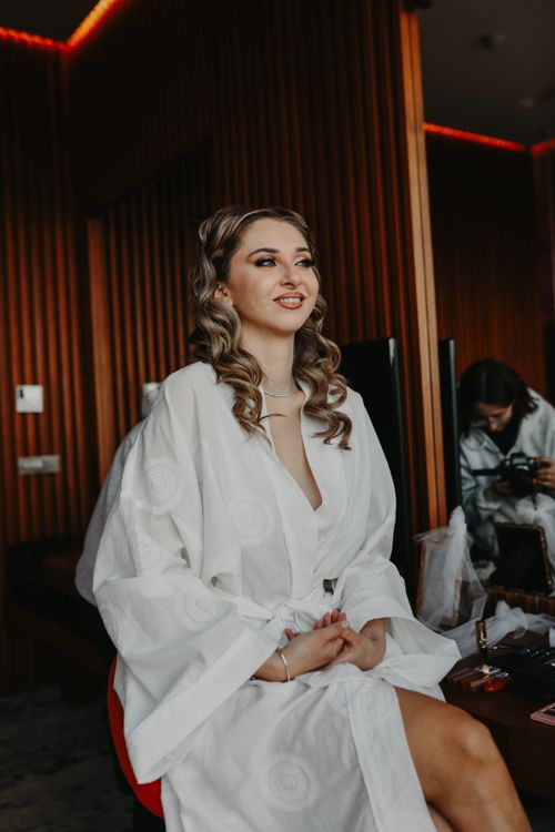 Free Bride in white robe preparing for her wedding day, captured candidly. Stock Photo
