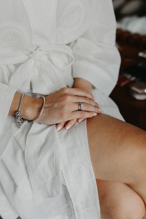 Free Close-up of a woman in a white embroidered robe showcasing delicate jewelry. Stock Photo