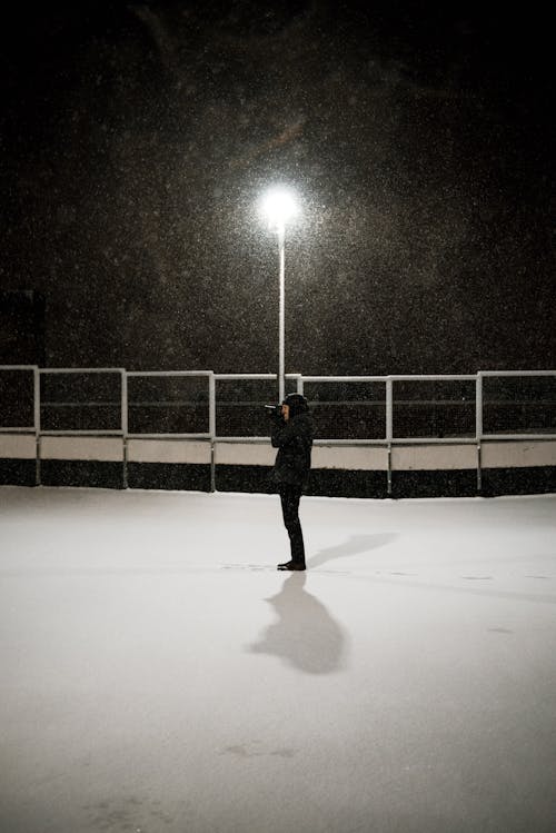 Free Man in Black Jacket Standing On White Snow  Stock Photo