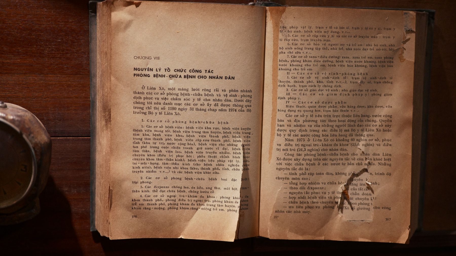 A vintage open book with text in Vietnamese on a wooden table, showcasing old literature.