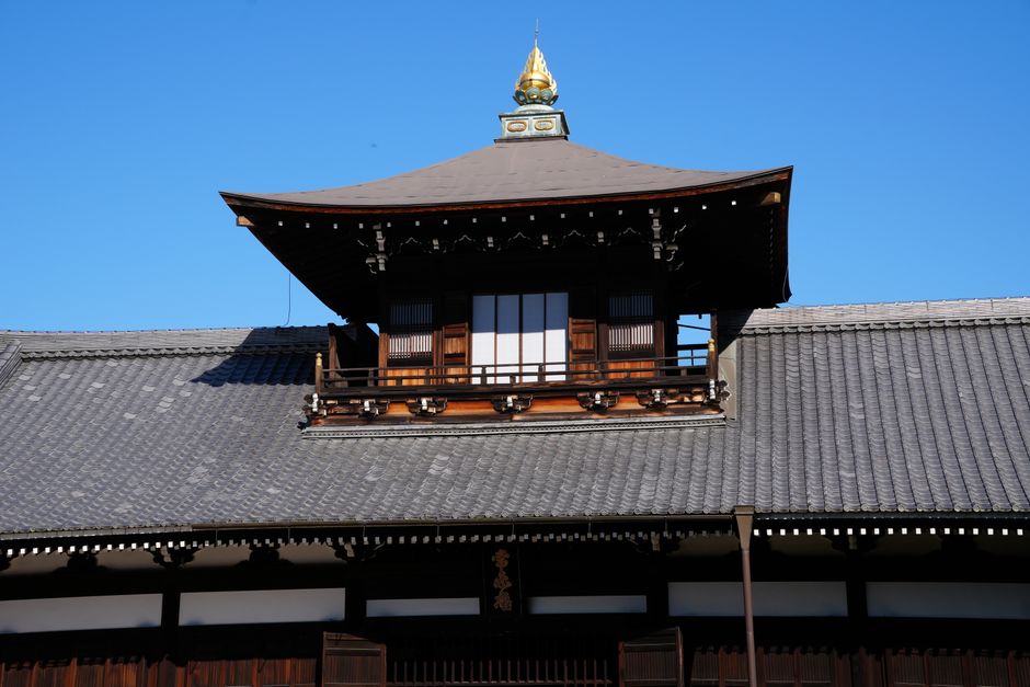 Elegant view of a traditional Zen temple roof with blue sky in Kyoto, Japan.