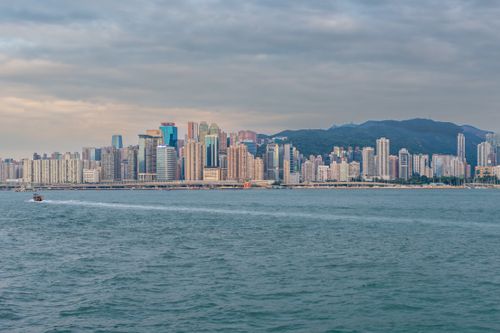 Free Breathtaking view of Hong Kong's skyline by day with a boat crossing the harbor. Stock Photo