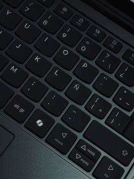 Detailed view of black Spanish keyboard keys with symbols and accents.