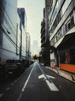 Narrow city alleyway with high-rise buildings in the background, capturing urban life.