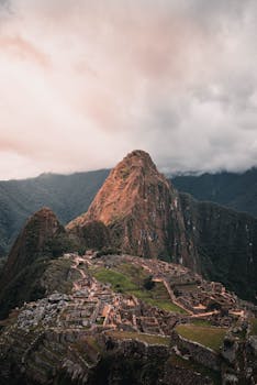 Explore the stunning aerial perspective of Machu Picchu, nestled in lush Peruvian mountains.