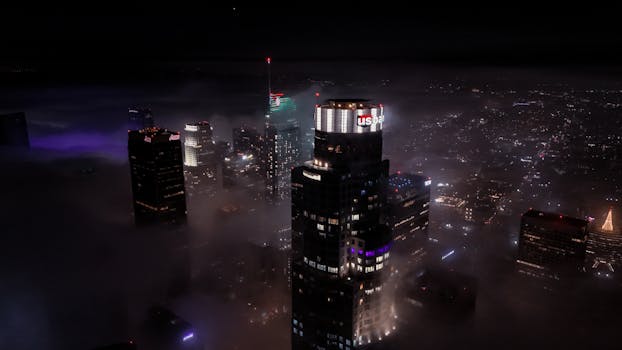 Stunning aerial view of foggy Los Angeles skyline at night showcasing city lights and skyscrapers.