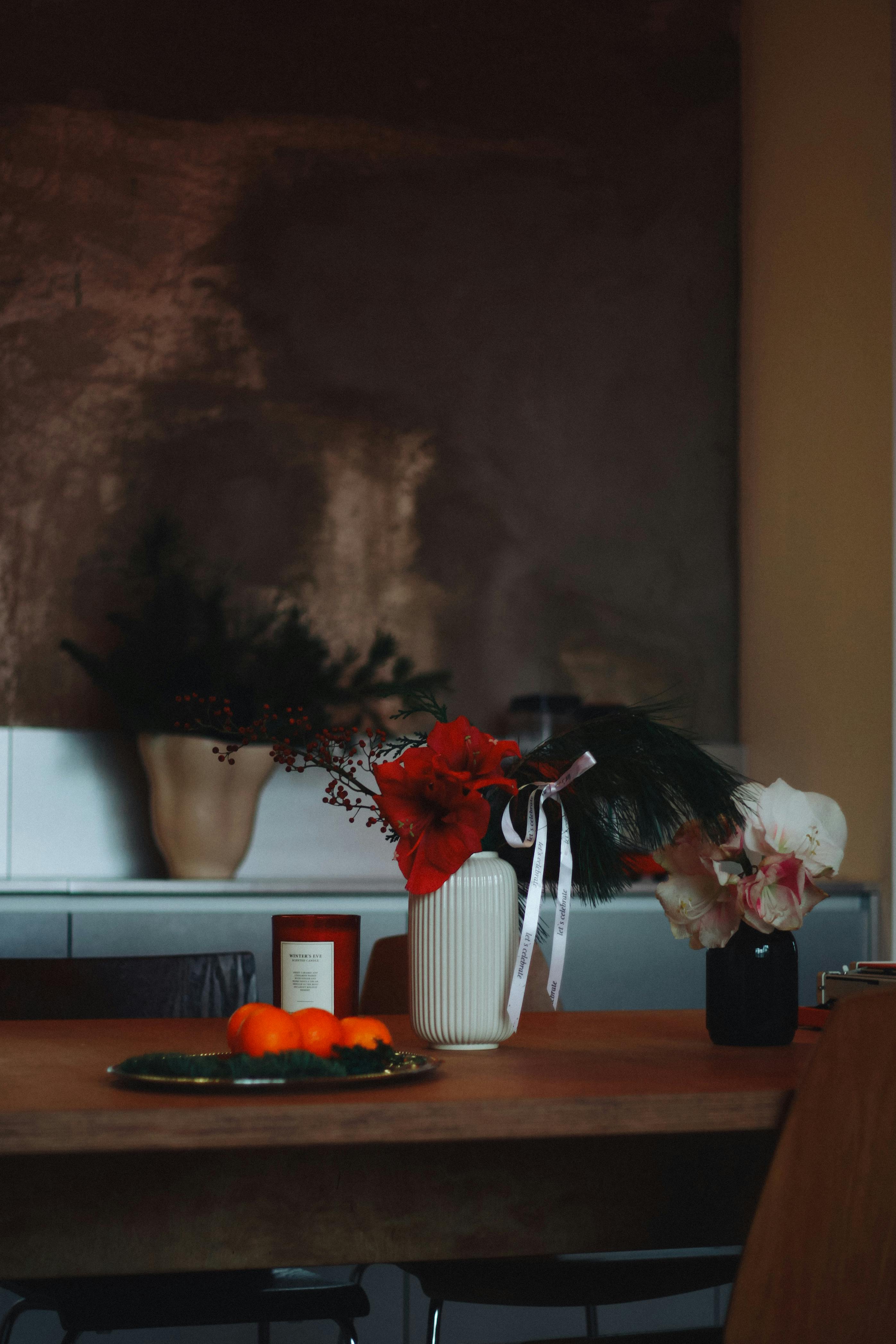 gratis Een stijlvolle tafelsetting met kleurrijke bloemen en verse citrusvruchten in een gezellige binnenruimte. Stockfoto