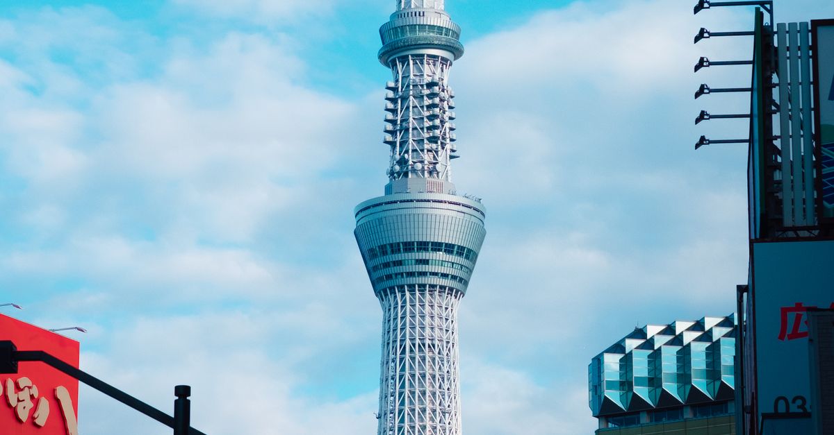 A breathtaking view of the iconic Tokyo Skytree, towering over the cityscape with clear blue skies.