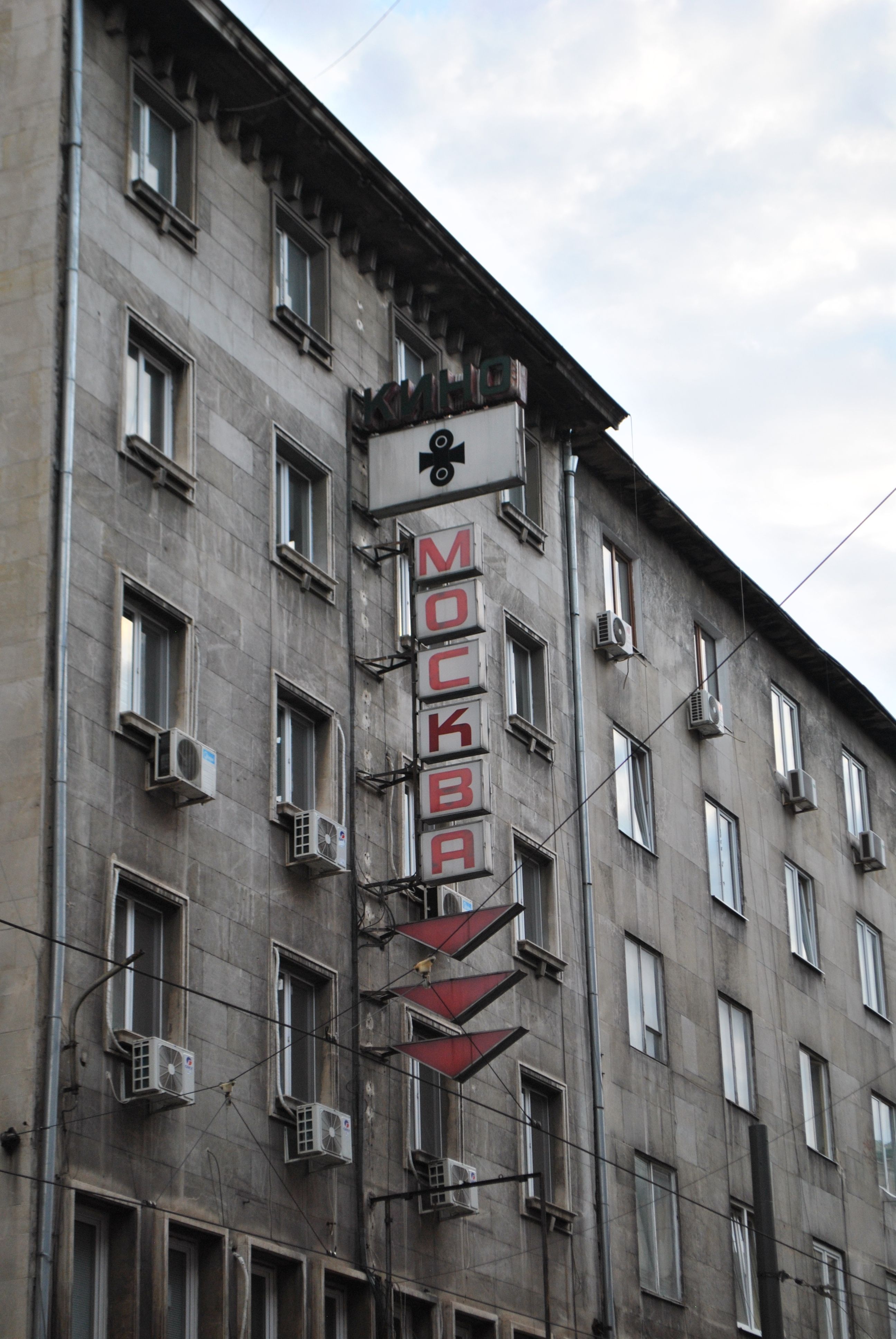 Old building with Moscow sign and air conditioners on facade.