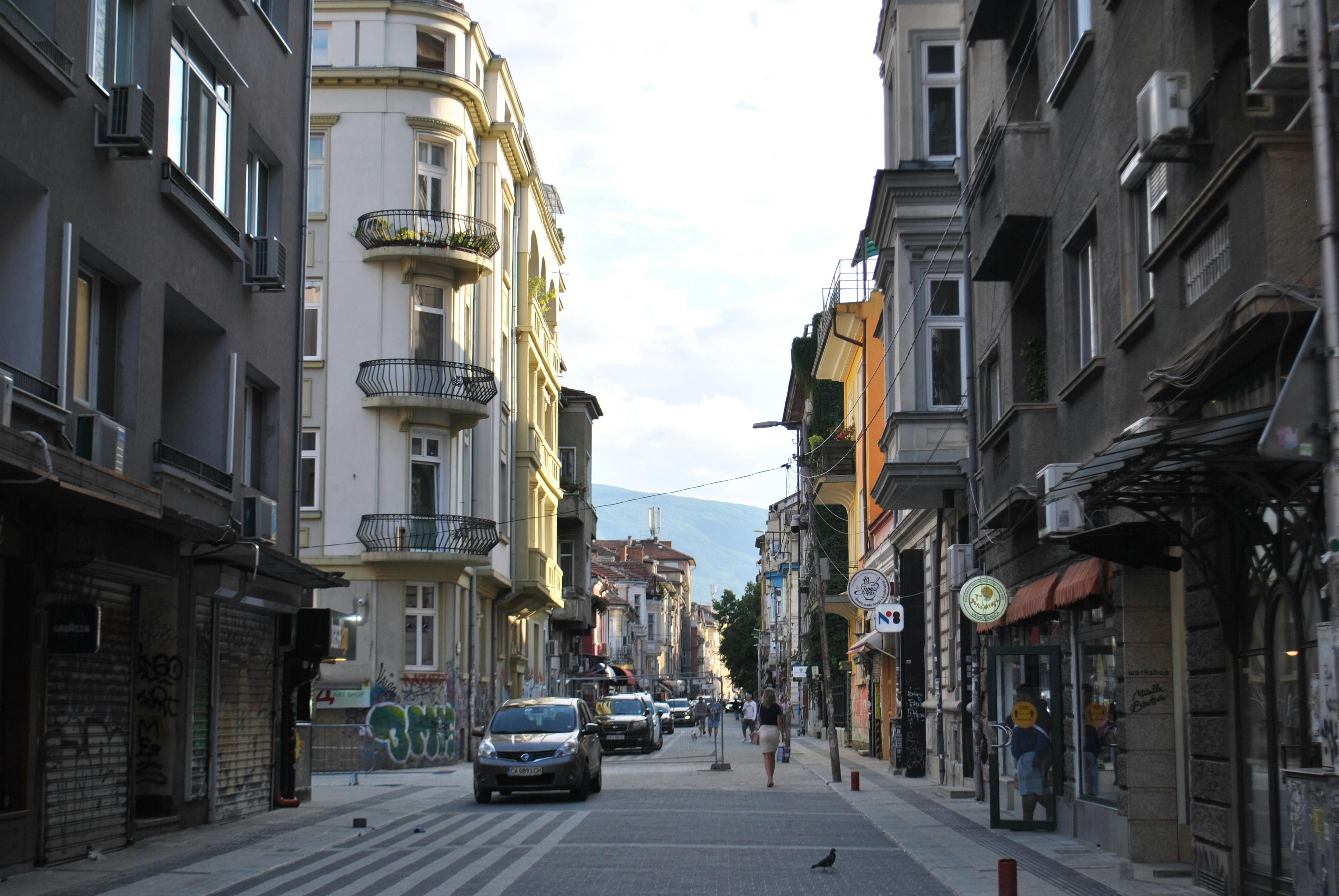 A picturesque European street scene with classic buildings and city life captured in soft daylight.