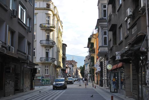 A picturesque European street scene with classic buildings and city life captured in soft daylight.