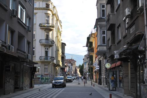 Free A picturesque European street scene with classic buildings and city life captured in soft daylight. Stock Photo
