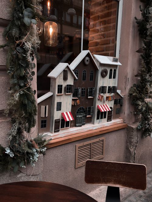 Free Rustic window display with decorative houses and festive garland outside. Stock Photo