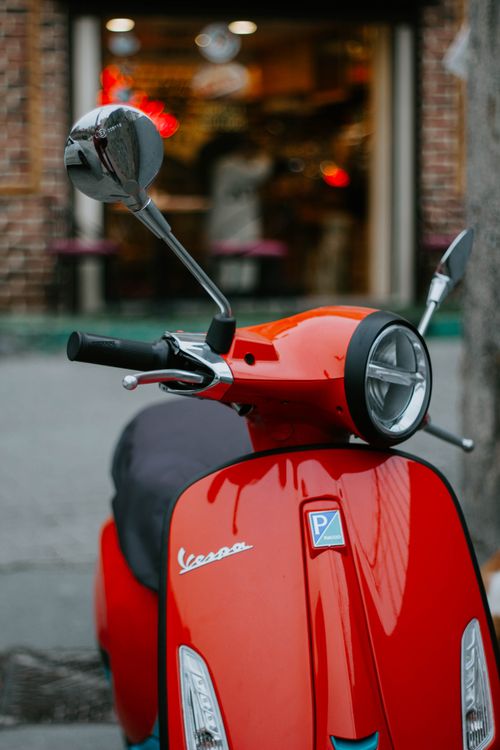 Free A vibrant red Vespa scooter parked outdoors on a street in Istanbul, capturing urban life. Stock Photo
