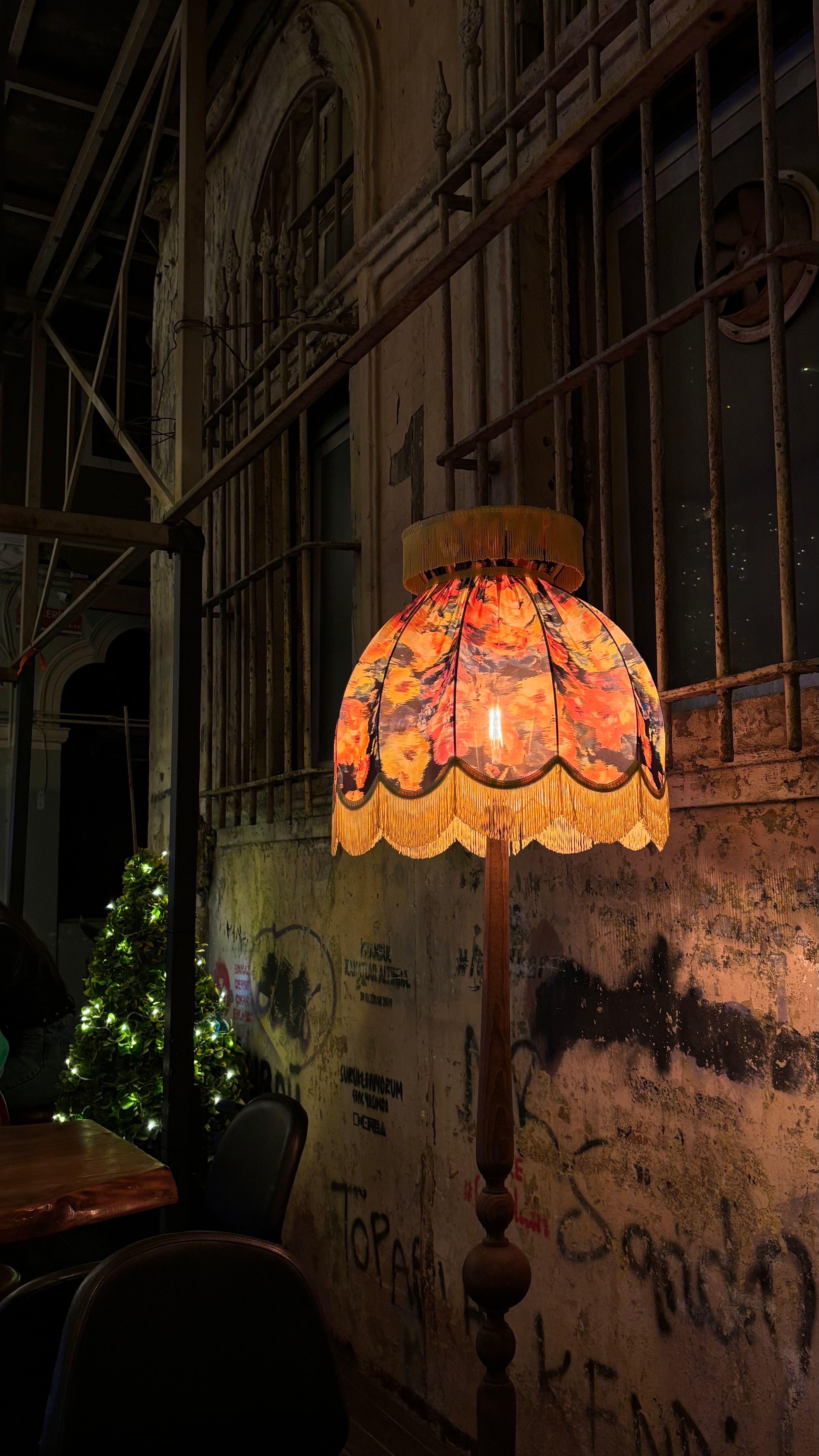 A cozy vintage lamp illuminating a rustic outdoor space with festive decorations.
