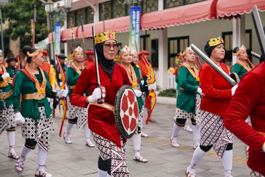 Traditional parade with participants in colorful costumes in Yogyakarta, Indonesia.