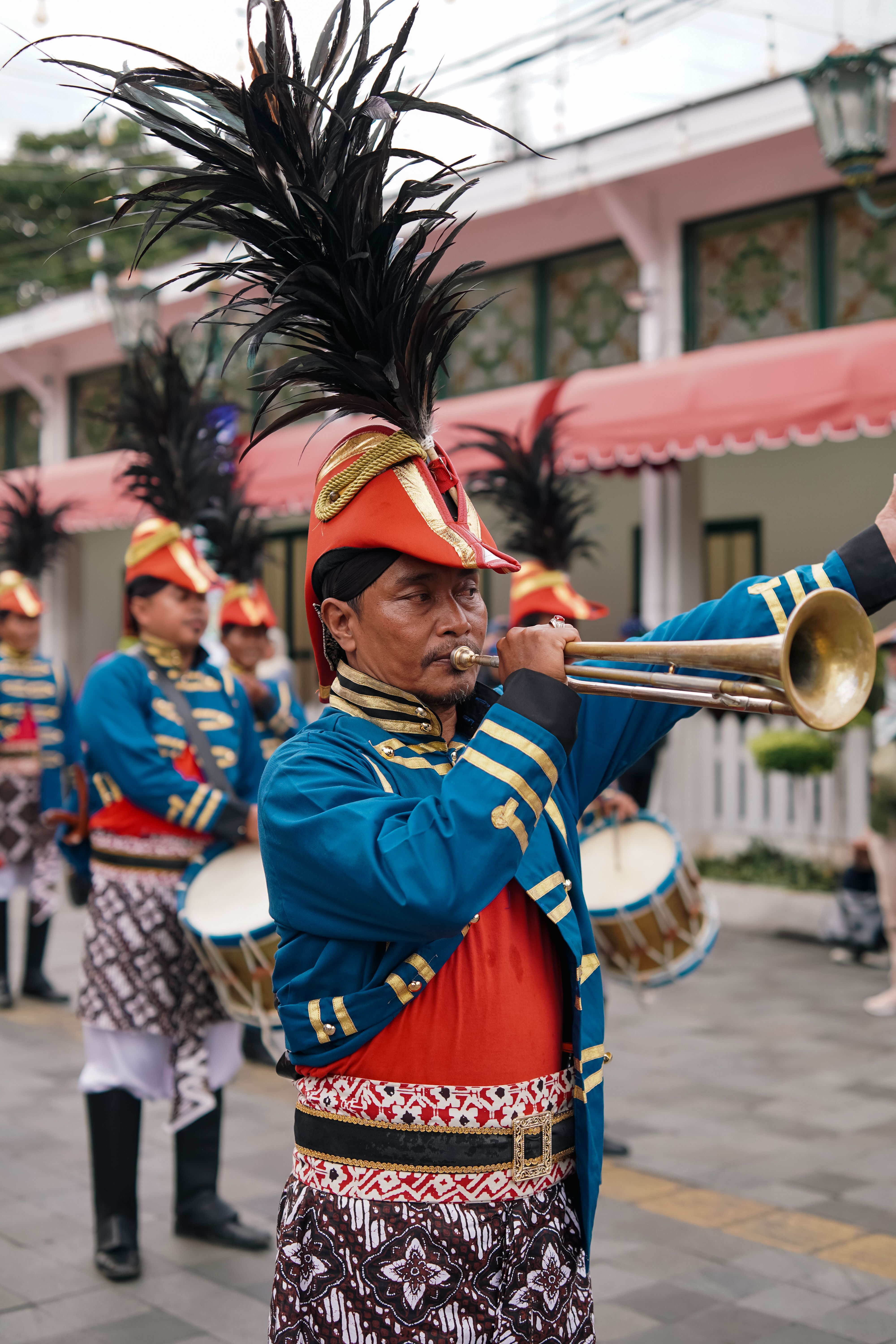 Colorful cultural parade in Yogyakarta featuring traditional costumes and musical performance.