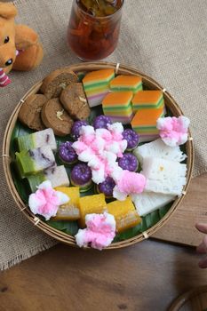 An array of vibrant Asian desserts in a bamboo basket, ideal for festive occasions. - Fotografer Sidoarjo