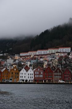  Charming view of colorful houses in foggy Bergen, nestled by the waterfront.