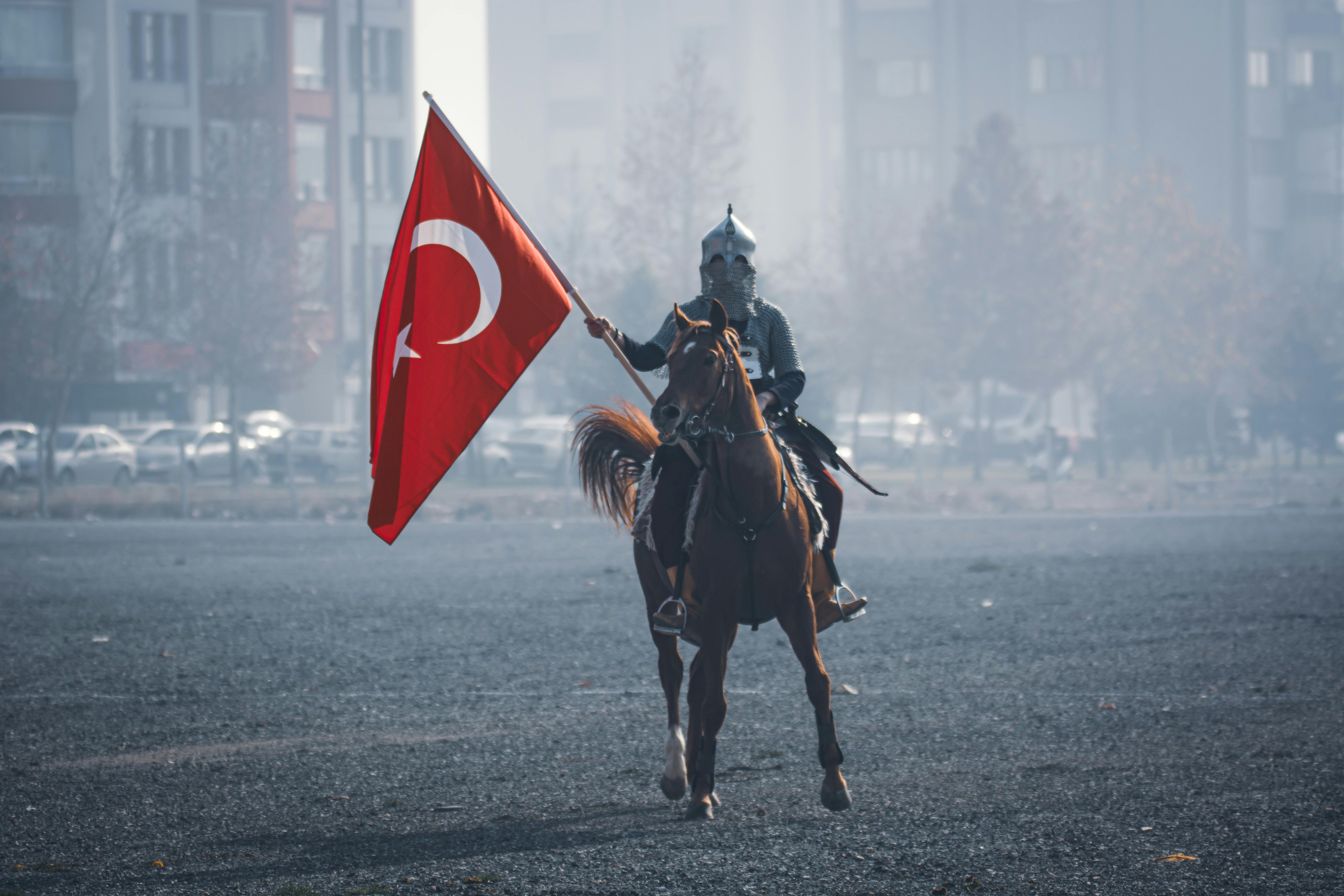 A historical reenactment of a Turkish horseman holding a flag in Konya, Türkiye.