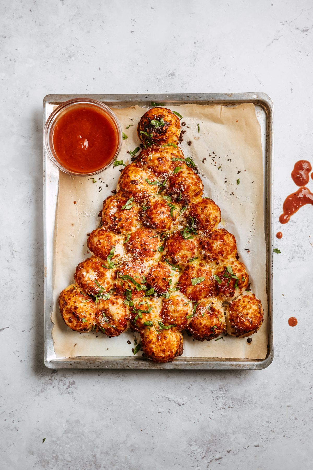 Pull apart bread shaped as a Christmas tree with tomato sauce