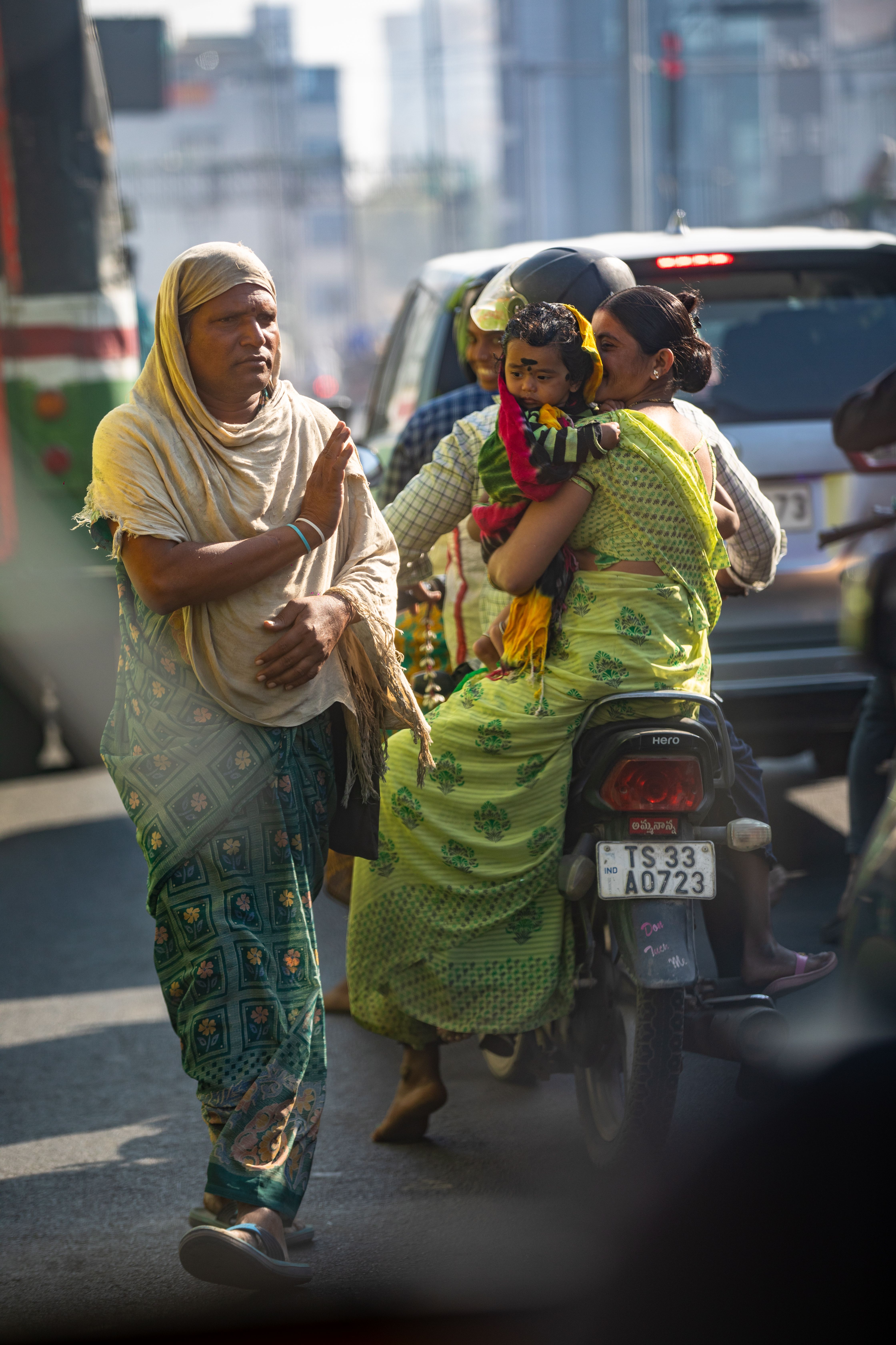 A bustling urban street with people, traffic, and dynamic interactions captured in daylight.