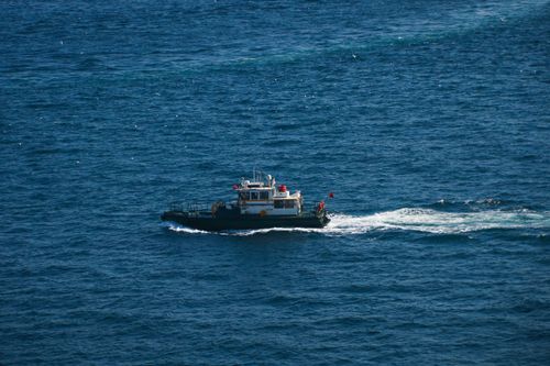 Free A small boat navigates the vibrant blue waters of Istanbul, Türkiye, under a clear sky. Stock Photo