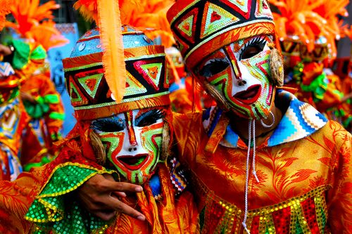 Free Colorful festival costumes and masks in a vibrant street parade, showcasing cultural heritage and celebration. Stock Photo