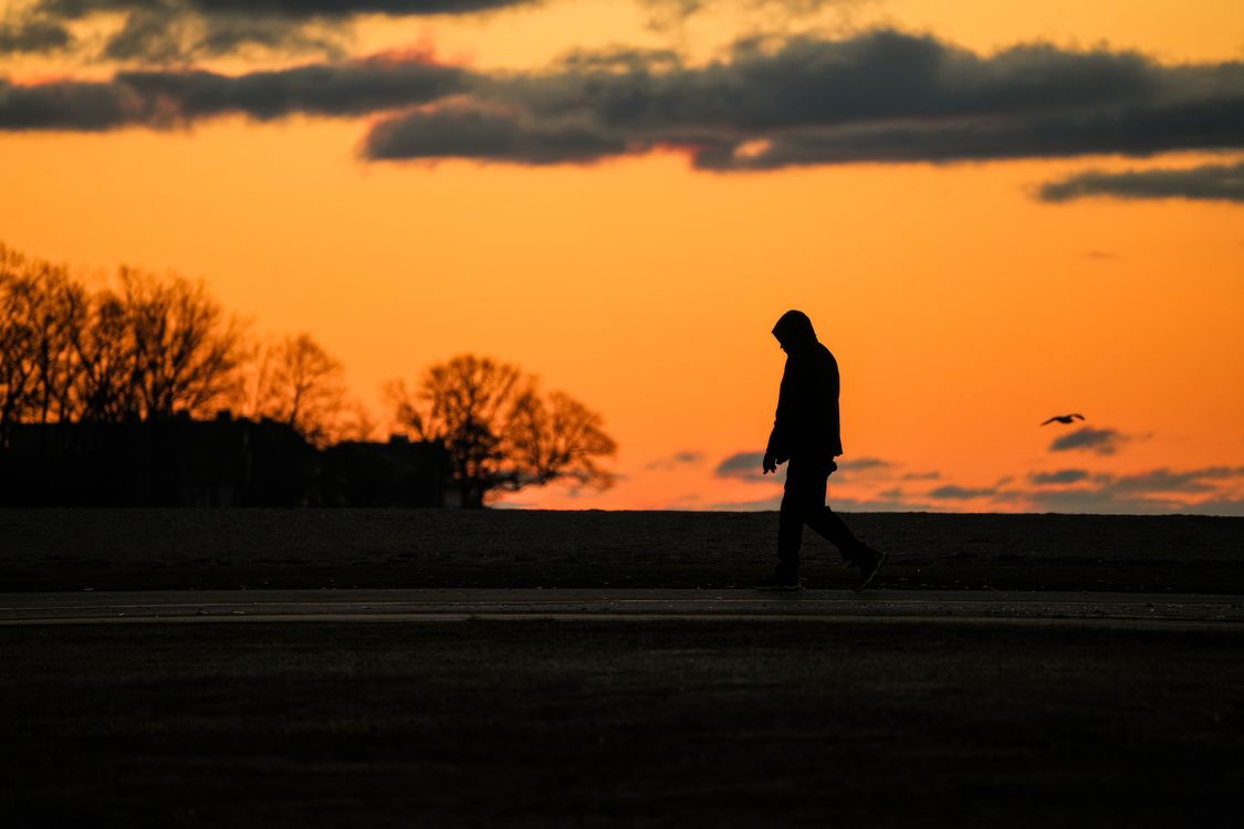 Silhouette of a Person Walking at Sunset · Free Stock Photo