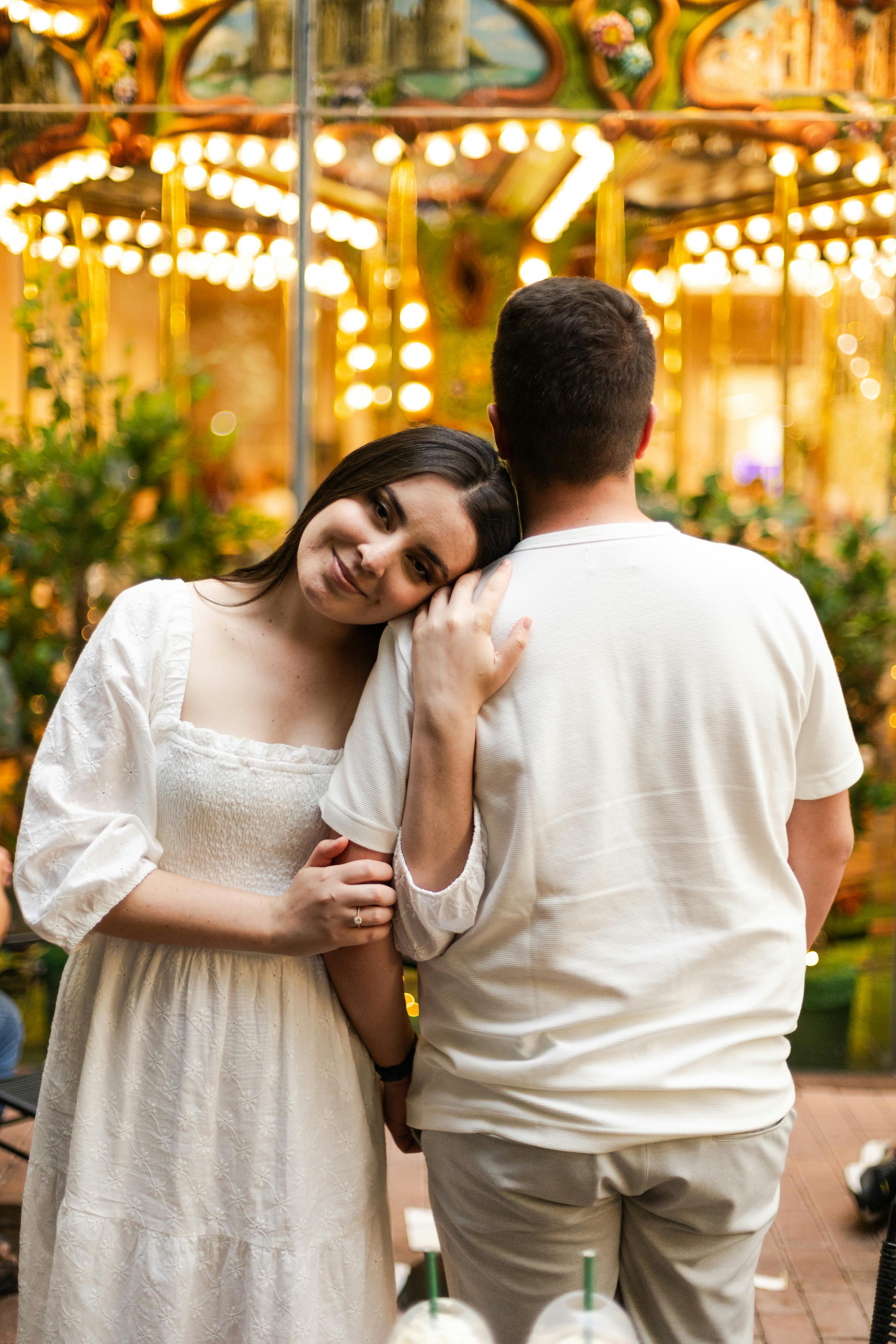 A couple enjoys a warm evening by a carousel in São Paulo, exuding love and joy.
