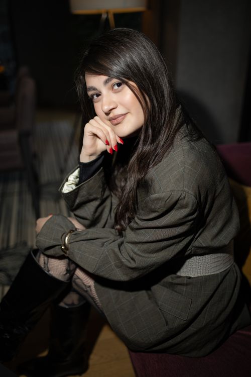 Free Charming young woman posing elegantly in a relaxed indoor setting. Stock Photo