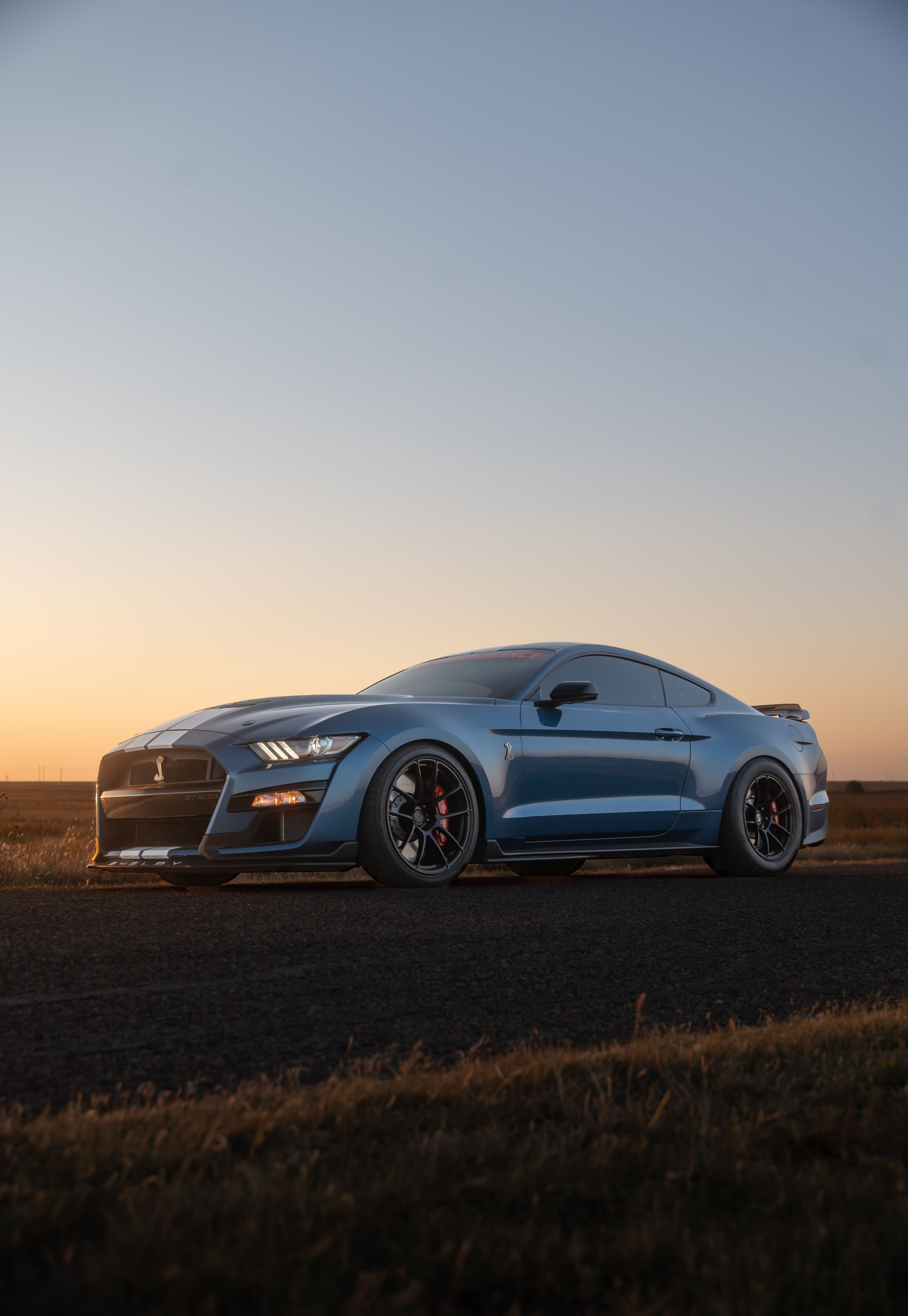 Sleek Blue Sports Car at Sunset on Open Road · Free Stock Photo