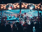 Vibrant Christmas market carousel at night with festive lights and decorations.