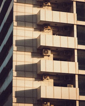 Close-up of a modern building facade casting geometric shadows with warm tones.