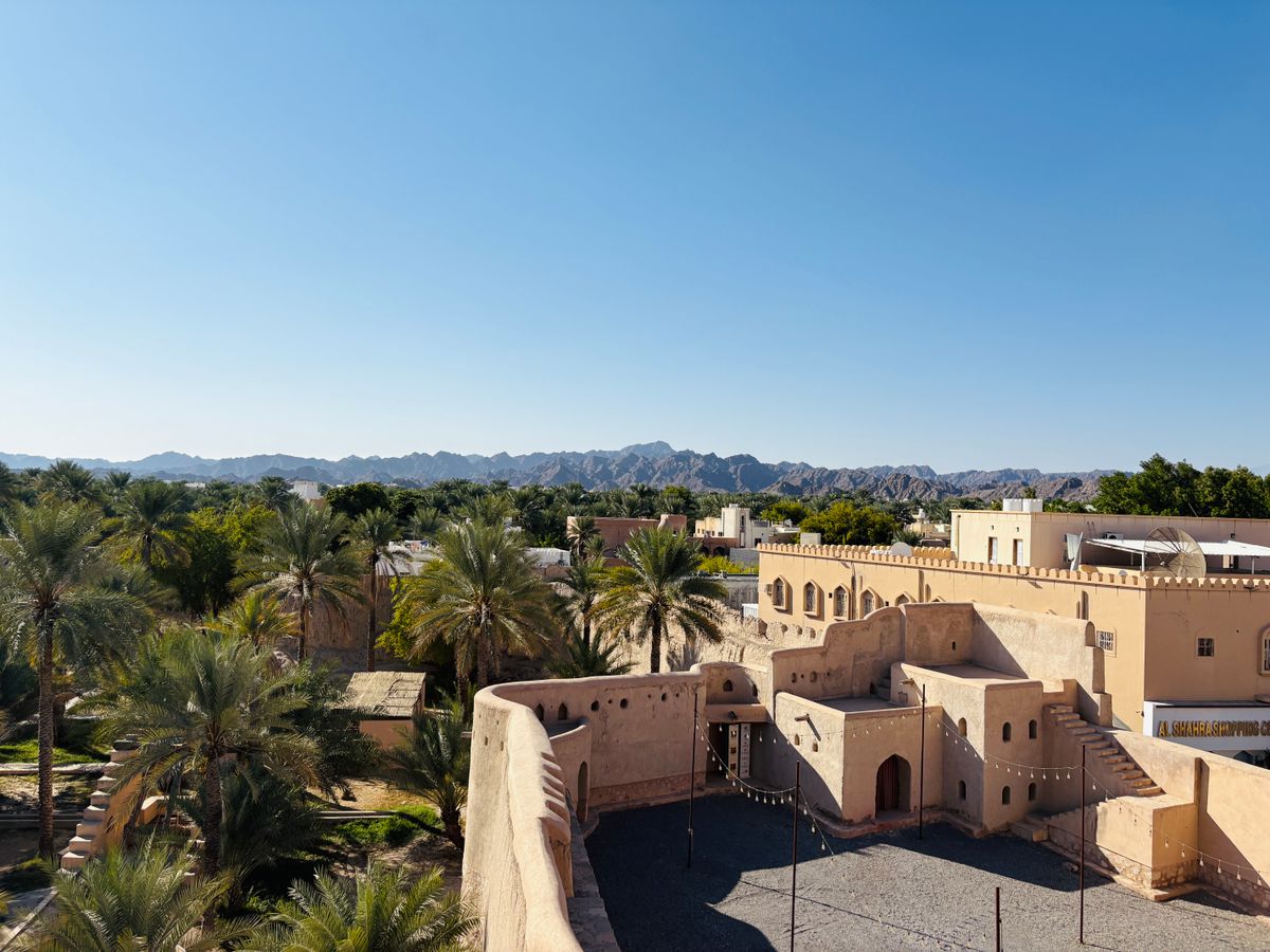 Nizwa Fort and its date-palm oasis below the Hajar Mountains