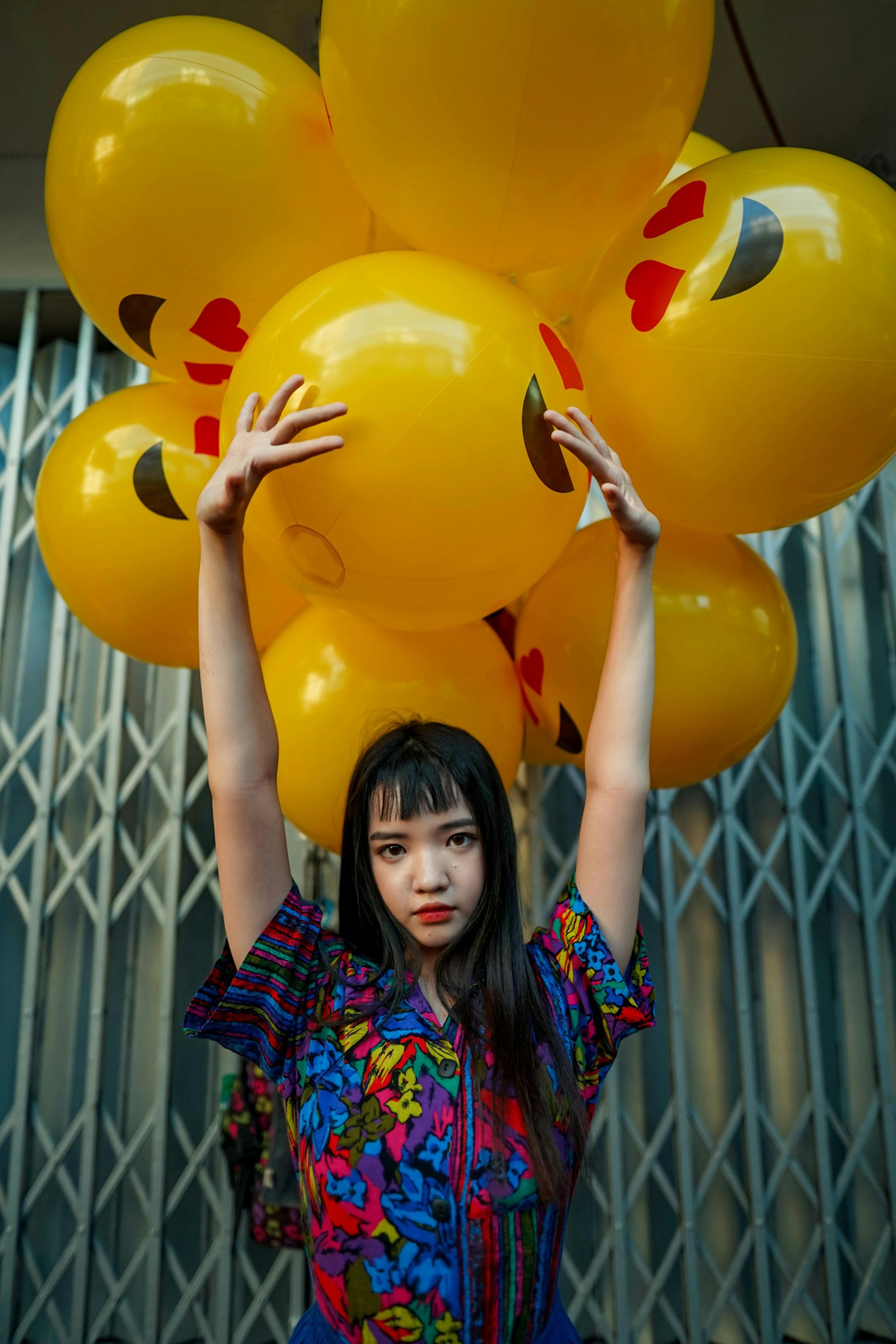 woman wearing blue top standing in front of yellow balloons