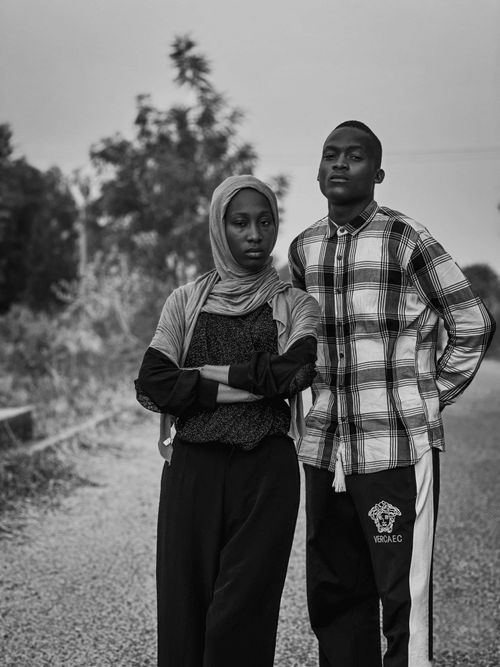 Free Black and white portrait of two young adults standing confidently outdoors. Stock Photo