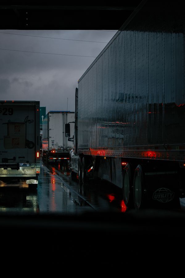 Vrachtwagens in file op snelweg bij regen