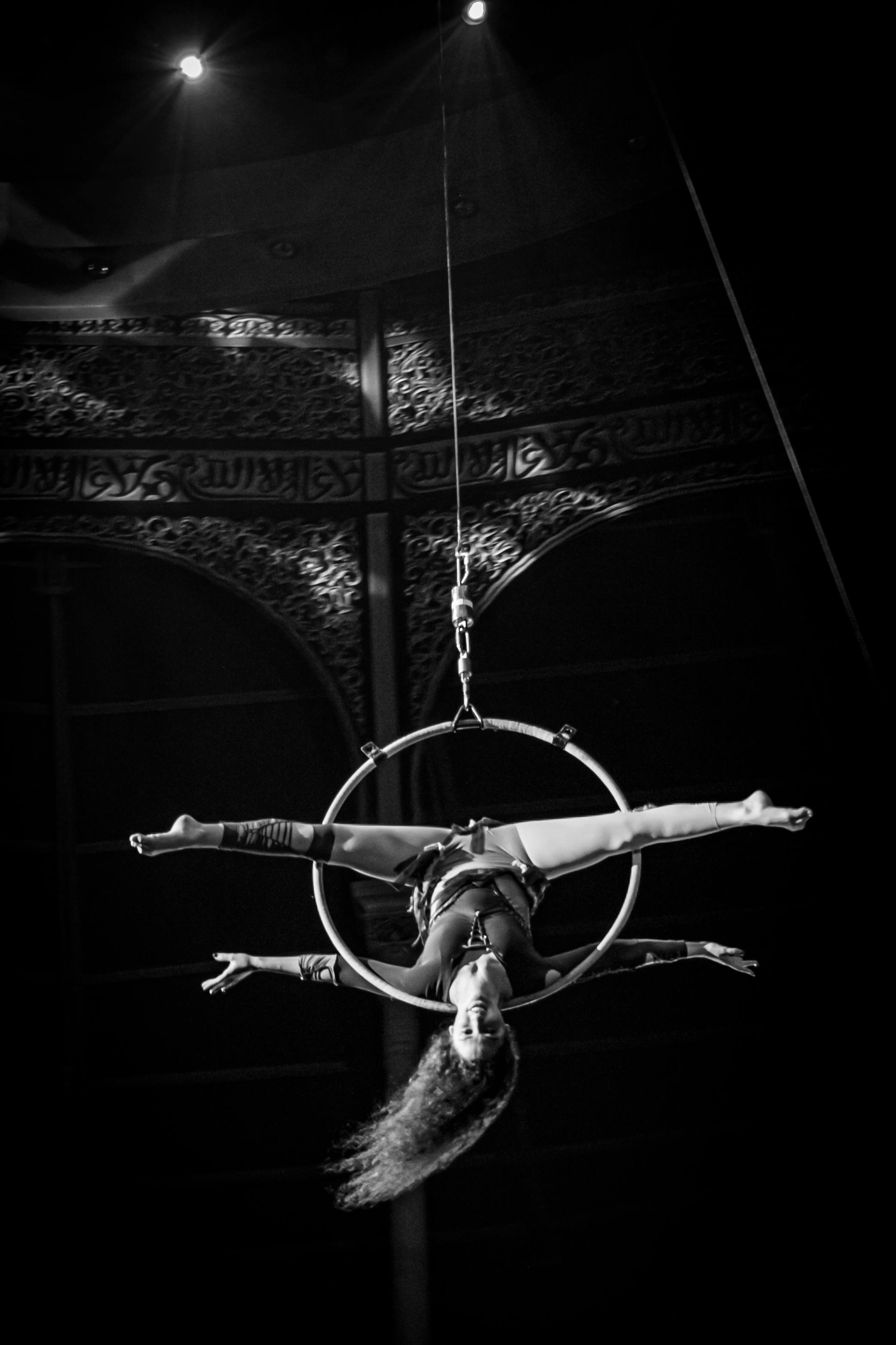 Free Black and white photo of a skilled aerial artist performing on a hoop, showcasing grace and strength. Stock Photo