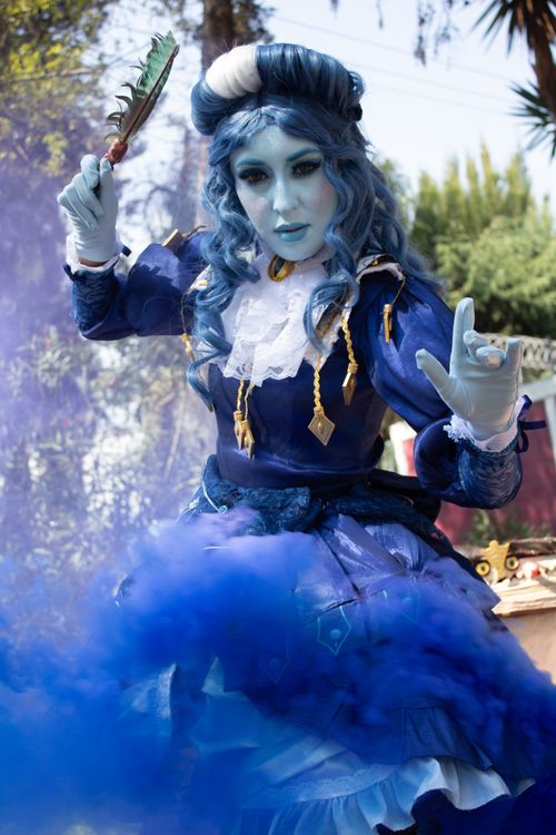 Free A person in a dramatic blue costume with a smoke effect, set outdoors. Stock Photo