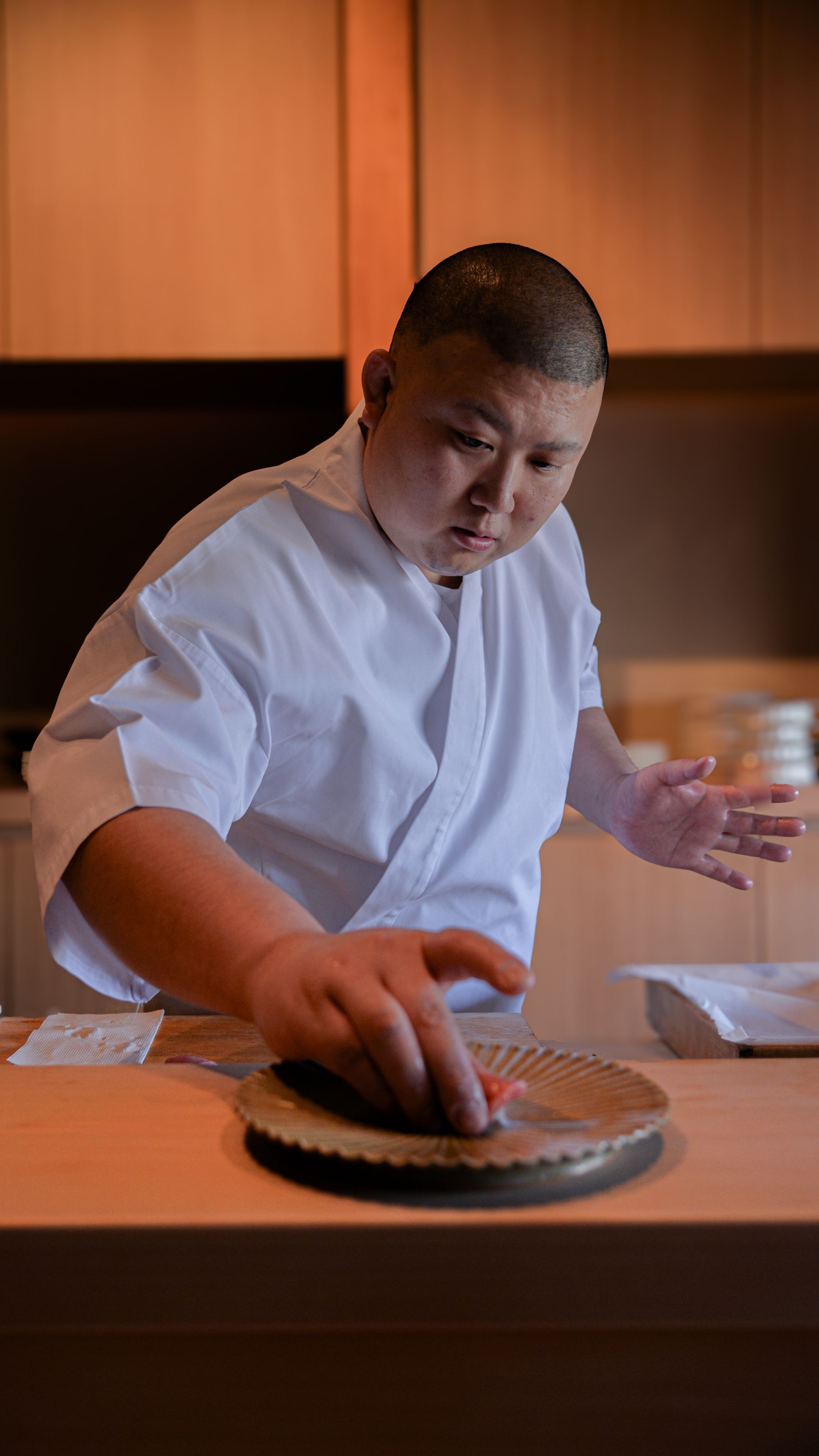Japanese chef preparing sushi with fresh fish in a traditional restaurant kitchen