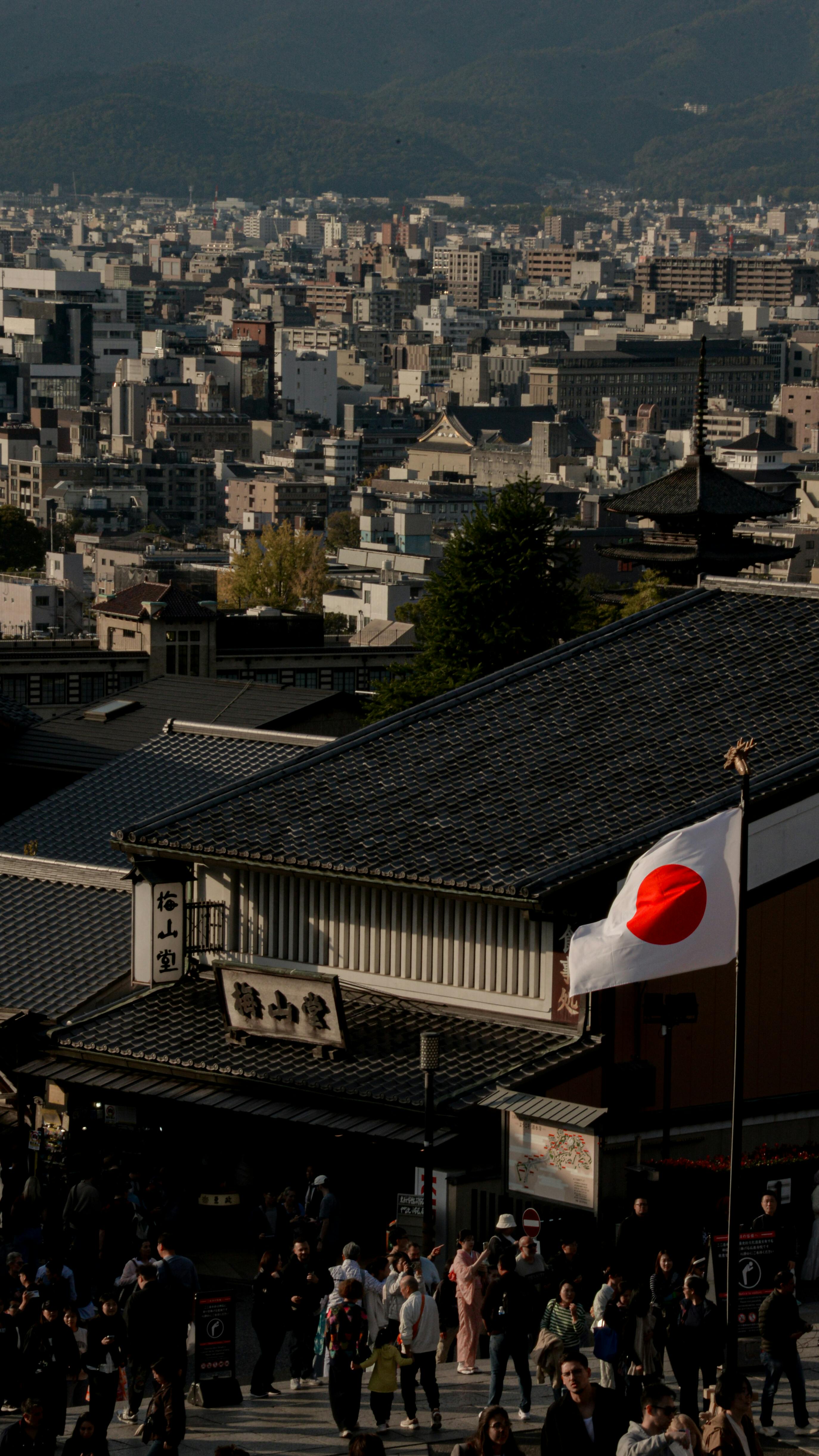京都的城市景观，传统建筑和清晰可见的日本国旗，展现了日本的精髓。