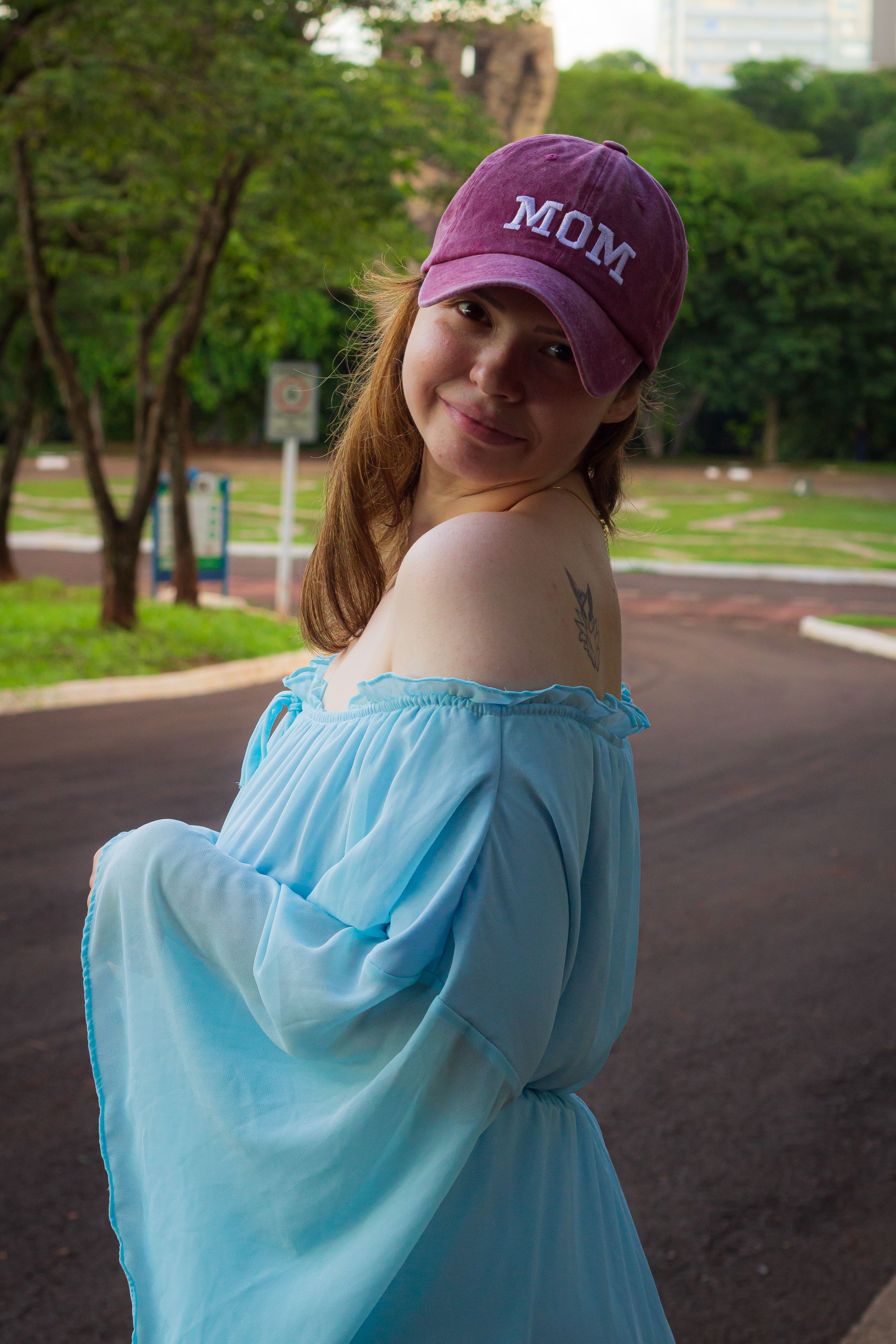 Young Woman Smiling Outdoors in Light Blue Dress · Free Stock Photo