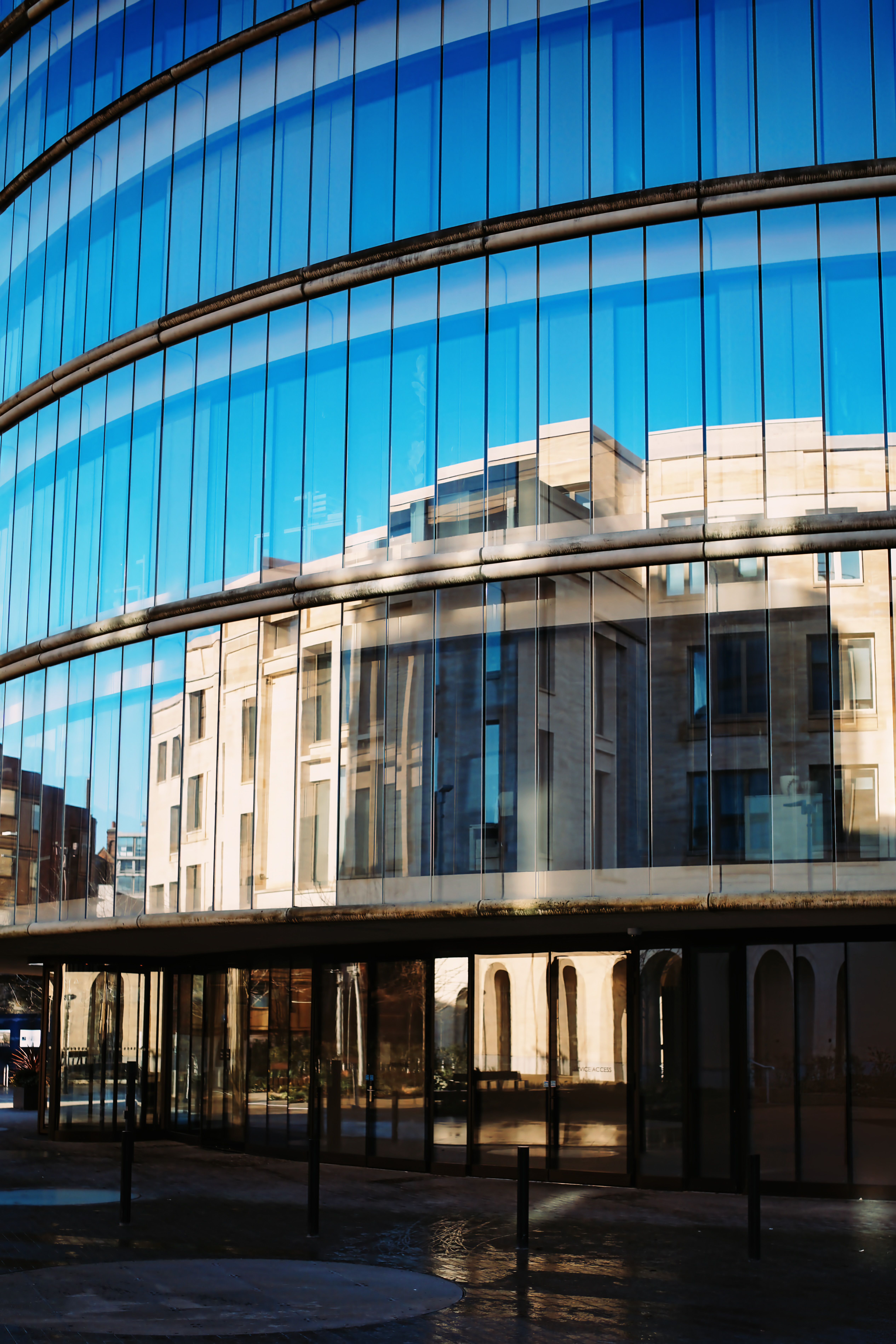Reflection of historic buildings on a modern glass facade in Oxford, England.