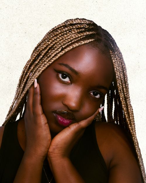 Free Close-up portrait of a woman with braided hair and serene expression, ideal for beauty and lifestyle themes. Stock Photo